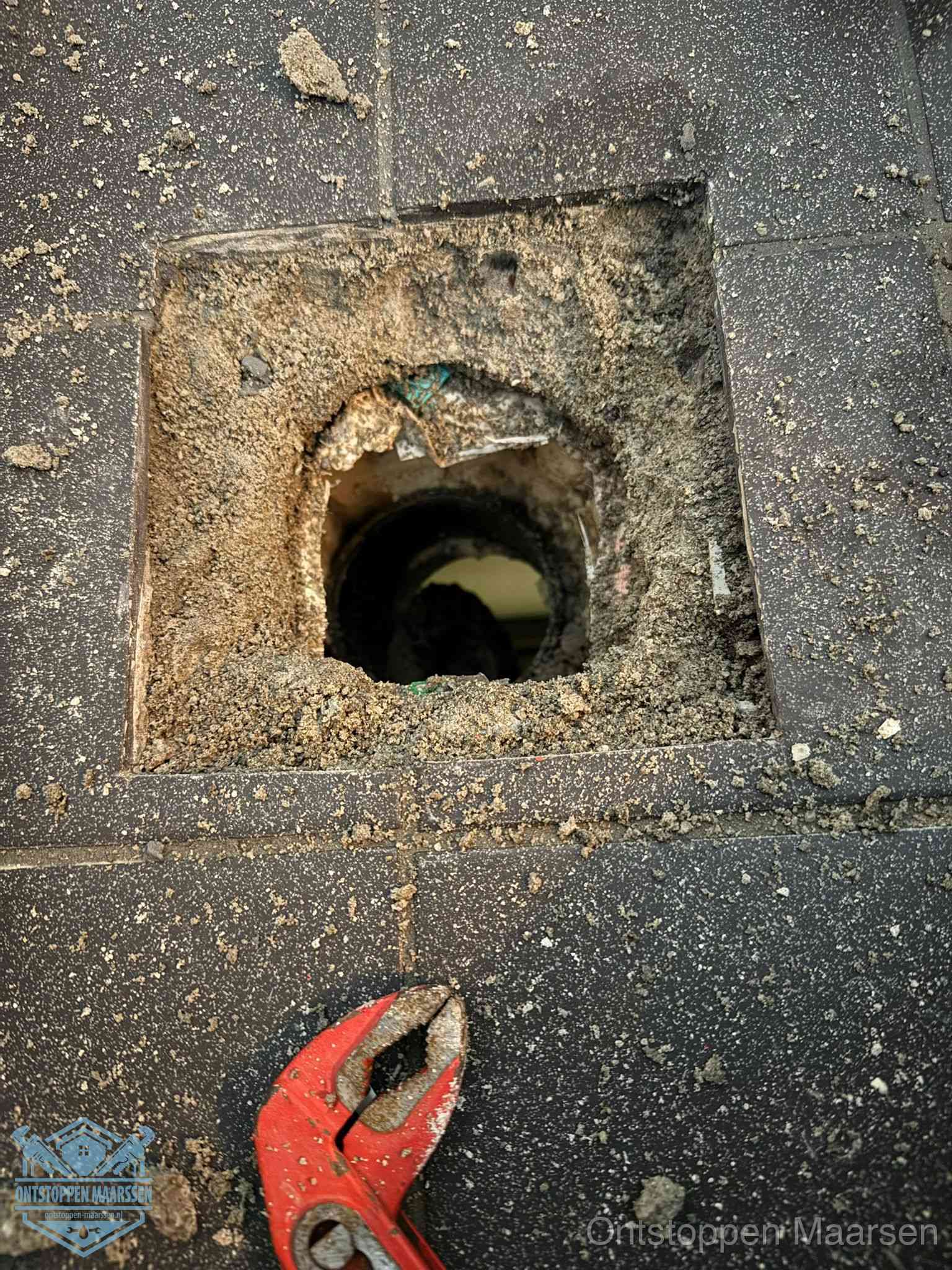 Geopend rioolputje op de erfgrens dat laat zien wie eigenaar is van de riolering in Maarssen