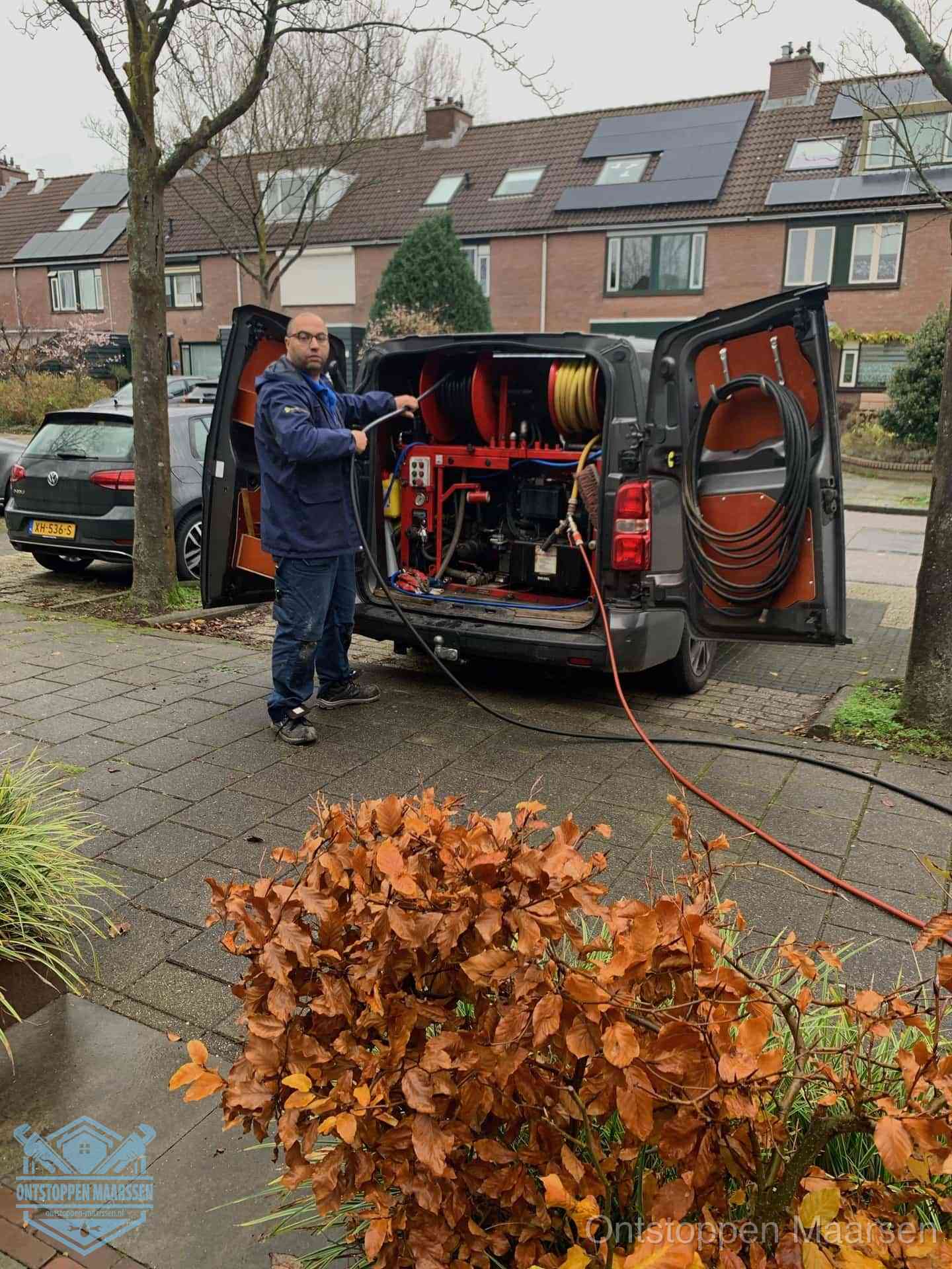 Monteur met rioolreinigingsbus levert rioolservice in de wijk in Maarssen