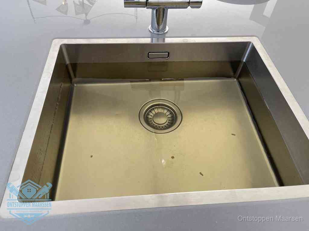 Stilstaand water in een rvs spoelbak dat niet wegloopt, een duidelijk signaal van een gootsteenverstopping in Maarssen