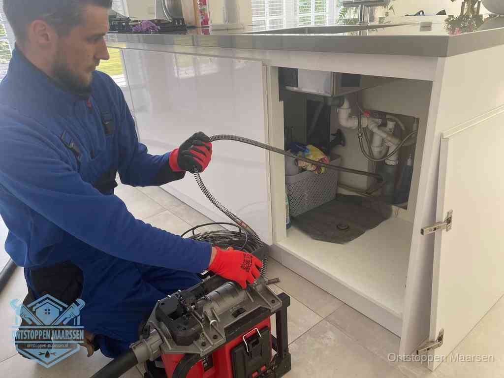 Een monteur reinigt de keukenafvoer grondig met een veermachine om terugkerende gootsteenverstoppingen te voorkomen in Maarssen